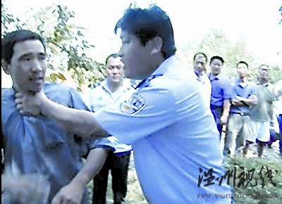 一村民欲阻止拆遷，被一個身穿監察大隊制服的工作人員掐住脖子，野蠻推開