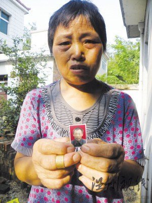 鮑祥義的妻子展示丈夫遺照。