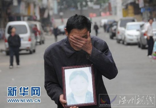 4月5日，在廣東省東莞市鳳崗鎮(zhèn)，肖國海捧著妻子吳喜英的遺像掩面哭泣。
