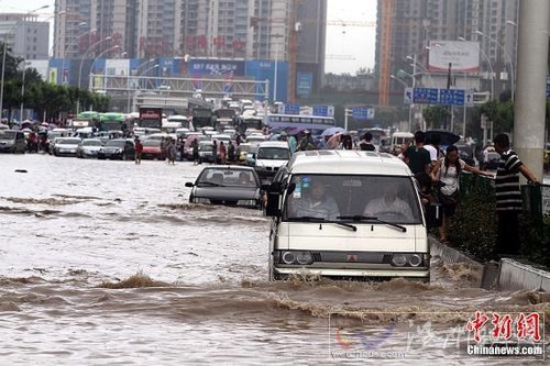 6月18日，車輛在武漢積水的道路上艱難行駛。當日，武漢降大到暴雨，全城多處交通要道積水嚴重，交通幾近癱瘓。中新社發 張暢 攝