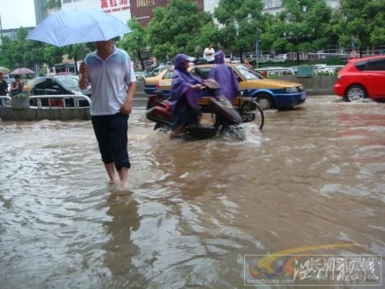 電動車和行人匆匆穿過芙蓉路的引橋，仍然還是要卷起褲腿。　　陳劍岷 攝 圖片來源：星辰在線