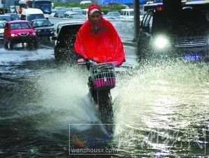 沖 潘家園橋下，一輛電動車從積水中通過，水花飛濺。本報(bào)記者 尹亞飛 攝