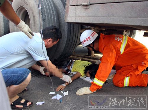 救援人員為壓在車輪下的女孩進行輸液