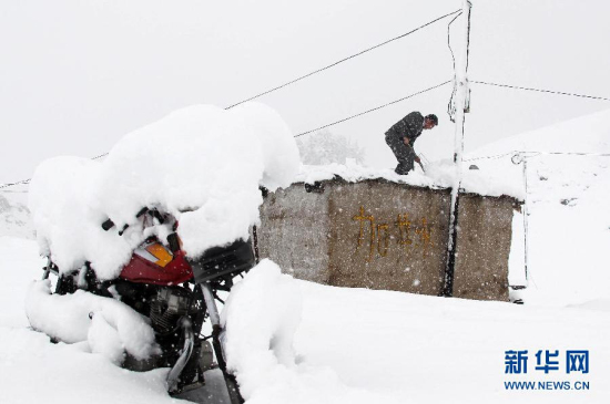 新疆哈密突降大雪 草原上的牧民在清理屋頂積雪